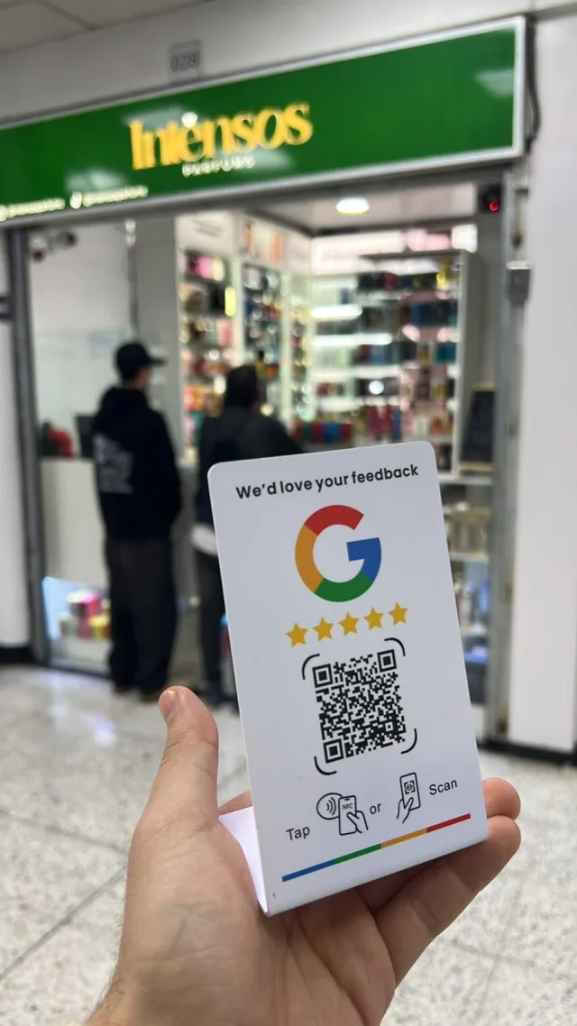Stand NFC + QR de reseñas en Google frente a la tienda Intensos Parfums
