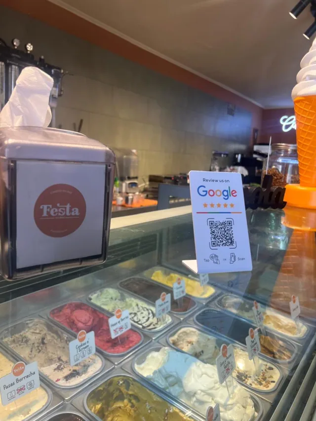 Stand blanco NFC + QR para reseñas de Google en el mesón de Festa Gelateria
