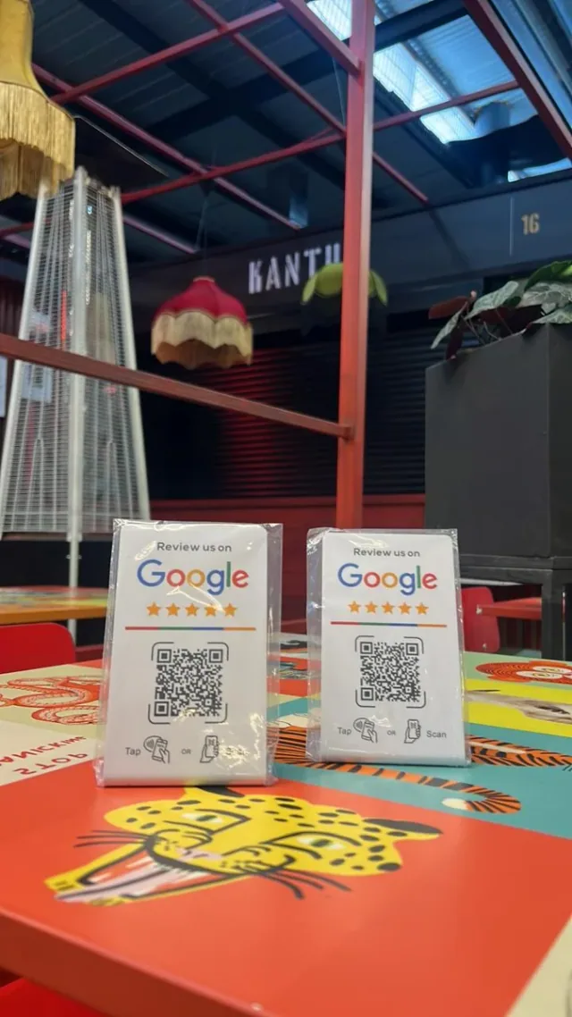 Dos stands blancos NFC + QR para reseñas de Google entregados a Kantu Food
