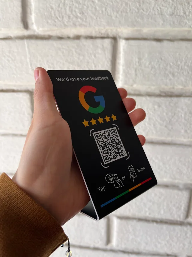 Stand negro NFC + QR de reseñas en Google sostenido por Constanza de Coni Nails